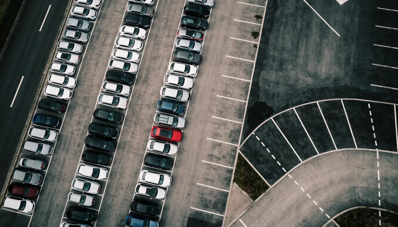 An overhead view of parked cars in a supermarket car park, showing the geometry of the marked bays.